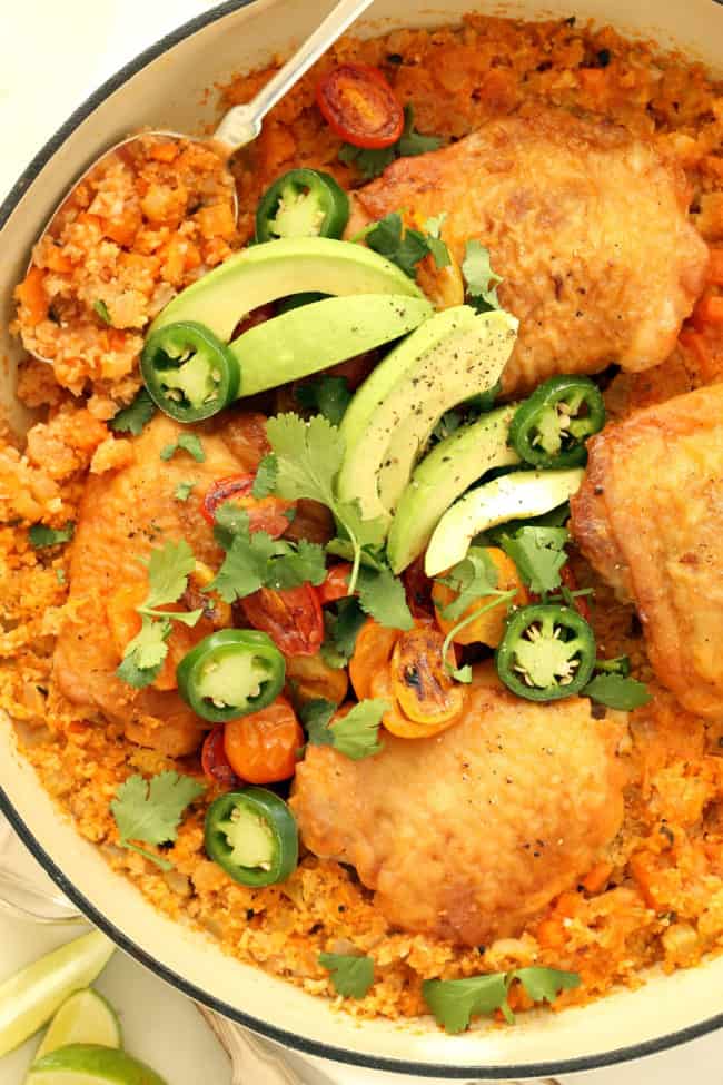 A white skillet filled with one pot Spanish chicken and cauliflower rice.