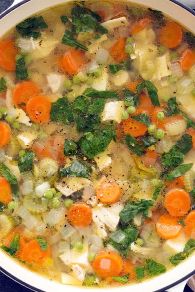 A white pot filled with chopped meat and veggies.
