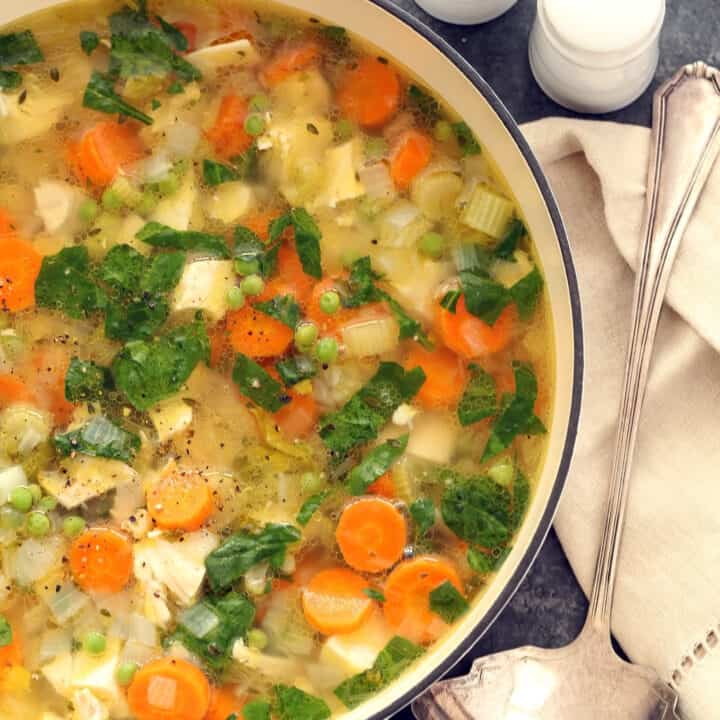 A white pot filled with Spring Chicken Vegetable Soup.