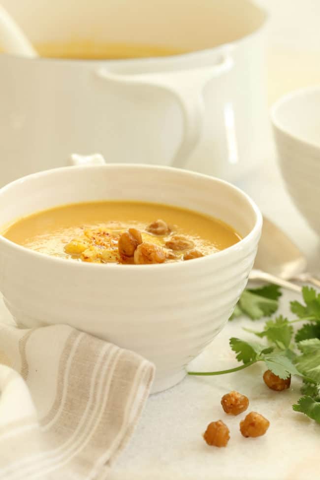 A large white cup willed with Curried Roasted Cauliflower Soup.