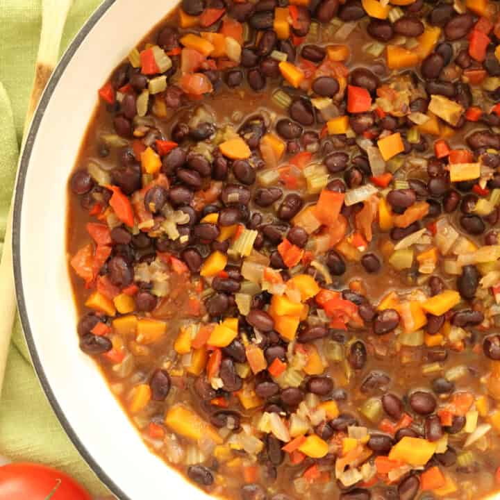 A white pot filled with blak bean stew.