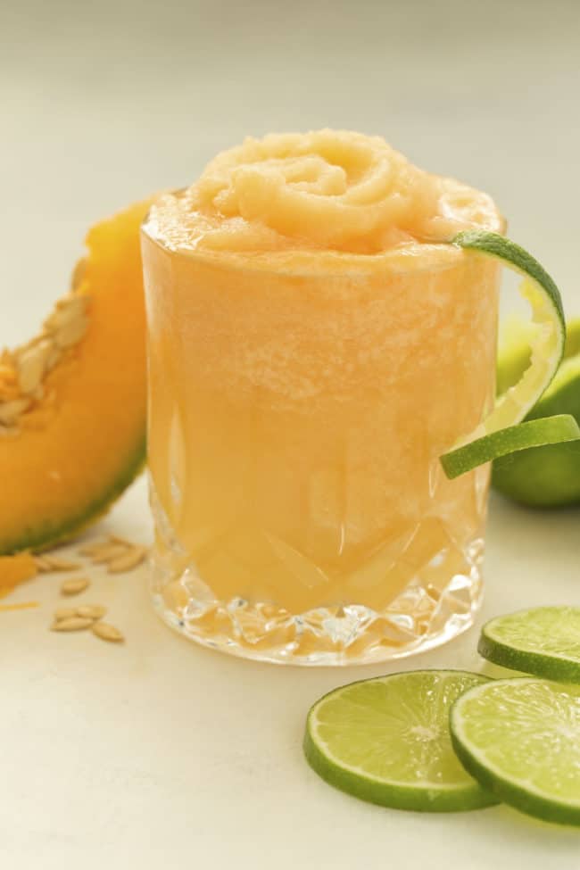 A clear drinking glass filled with cantaloupe slushie.