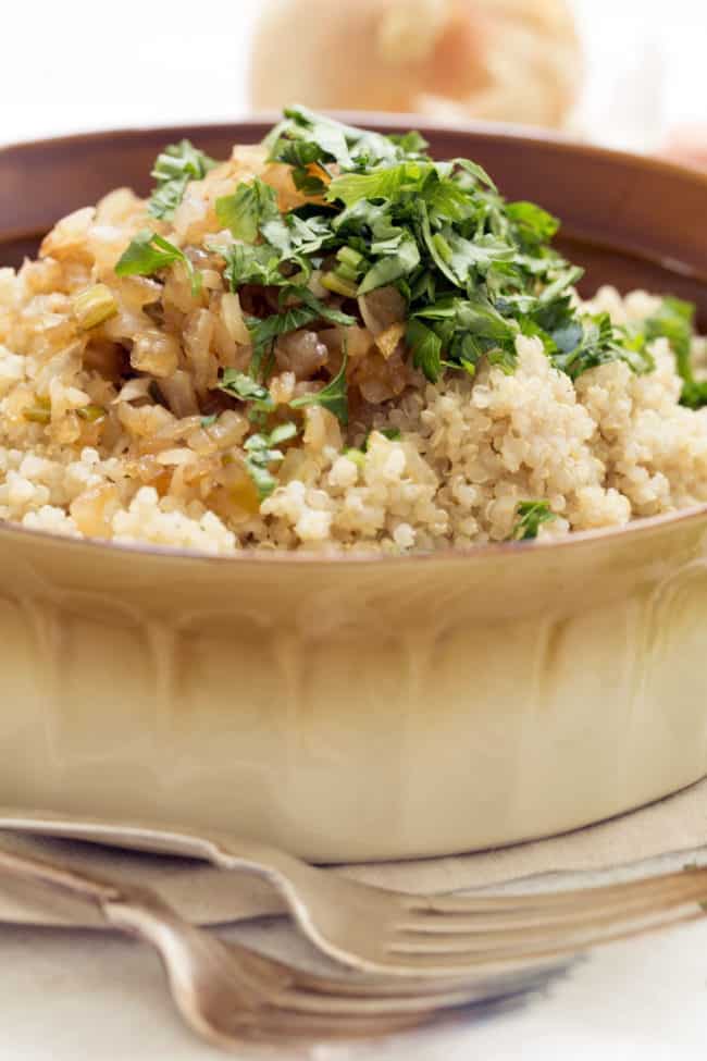 A brown bowl filled with a grain side dish.