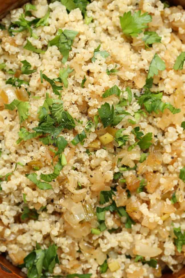 A brown bowl filled with cooked grains.