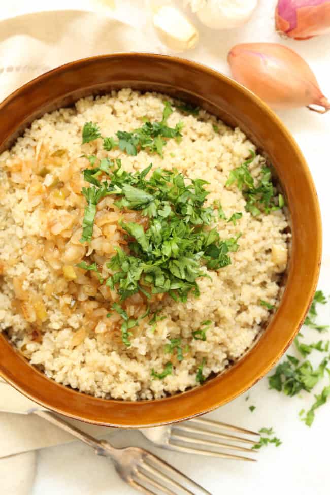 A brown bowl filled with caramelized onion quinoa.