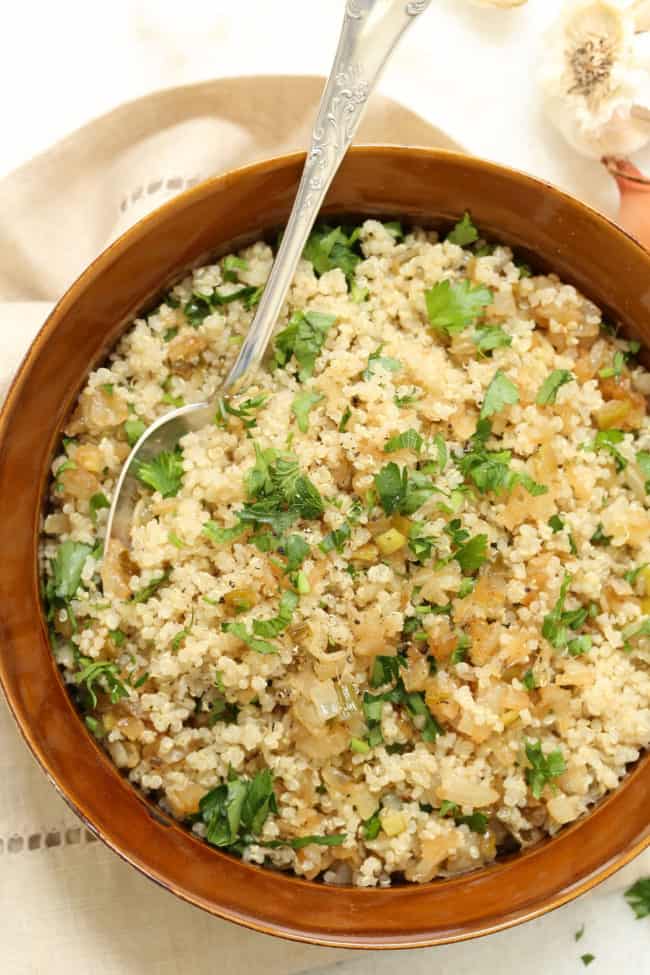 A brown bowl filled with caramelized onion quinoa.