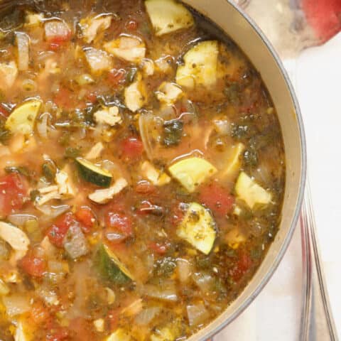 A red pot filled with healthy Chicken Tortilla Soup.