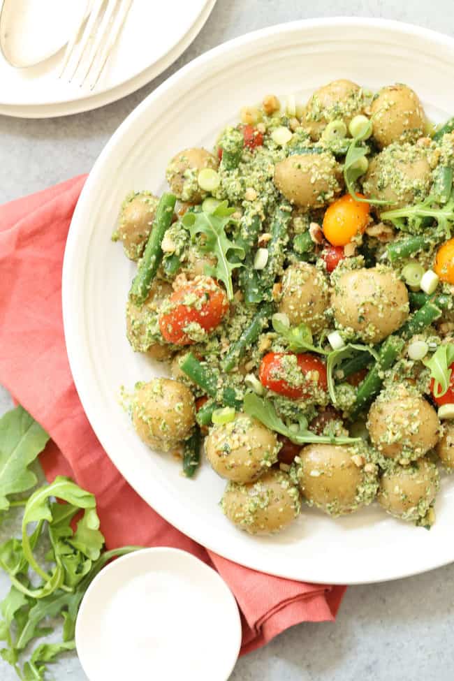 A white bowl filled with Pesto Potato Salad.