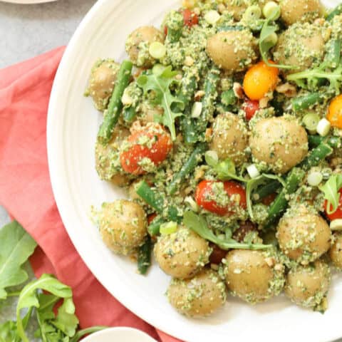 This Arugula Pesto Potato Salad is likely to be one of the easiest potato salads you'll ever make.    Tender baby potatoes are mixed with green beans and heirloom cherry tomatoes, then it's all tossed in a delicious nutty arugula pesto