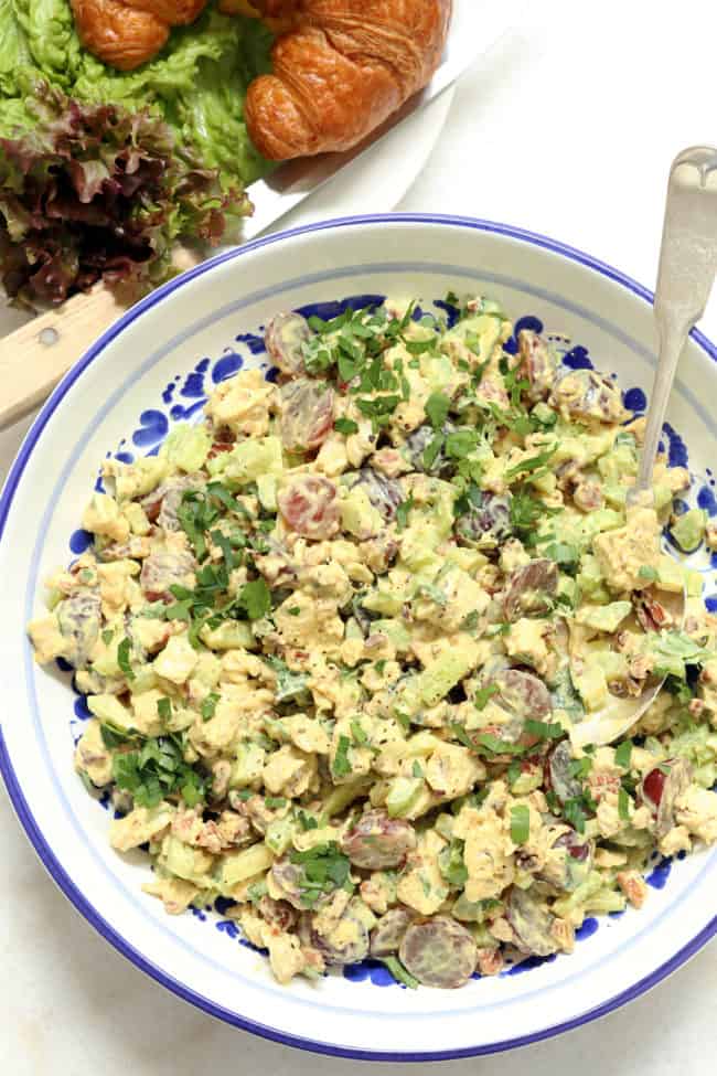 a blue and white bowl filled with chicken curry salad