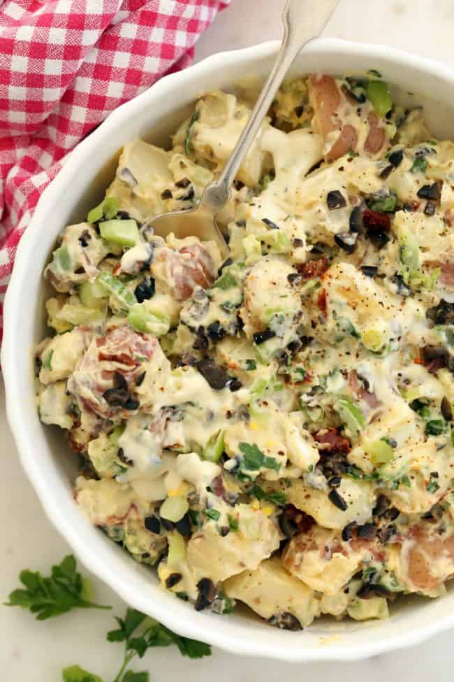 A white bowl filled with roasted garlic potato salad.