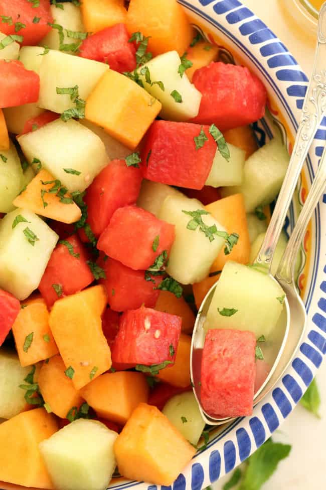 A blue and white bowl filled with melon salad.