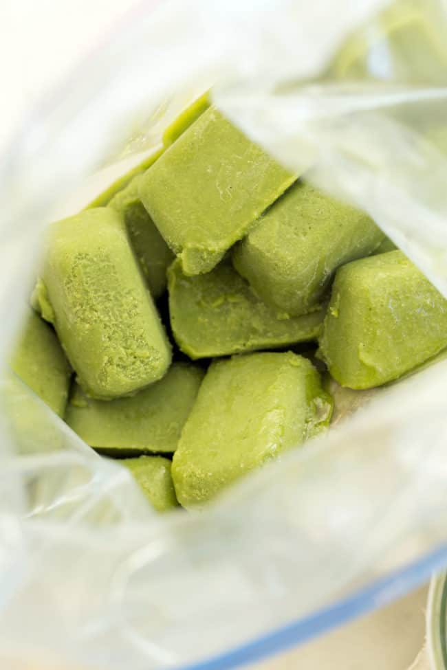 A freezer bag filled with frozen pesto ice cubes - how to freeze pesto recipe