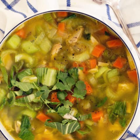 A white pot filled with Immune Boosting Chicken Soup.