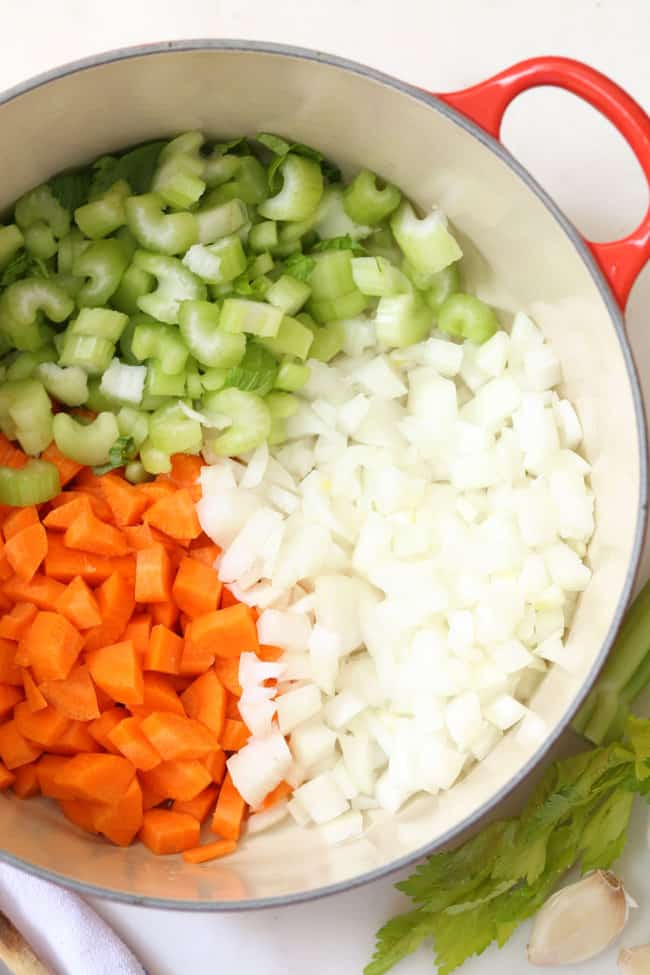 A red pot filled with chopped vegetables.
