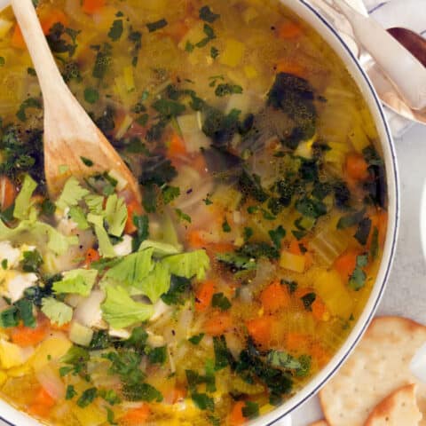 A white pot filled with Roasted Garlic Chicken Soup.