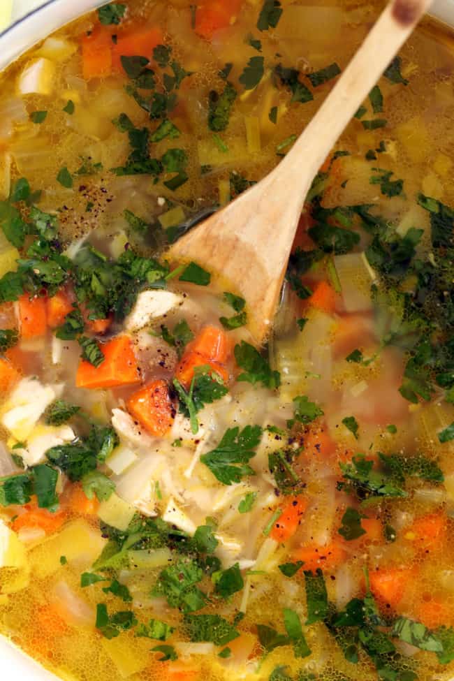 A white pot filled with soup.