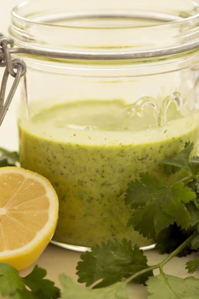 A mason jar of homemade lemon herb vinaigrette.