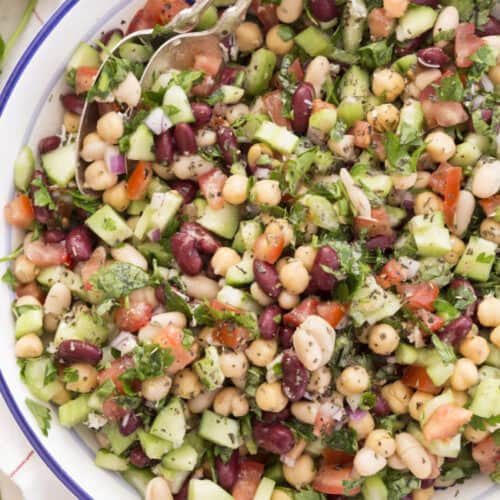 A colorful bowl of summer salads featuring summer pasta salad, summer fruit salad, and a summer strawberry salad with fresh ingredients.