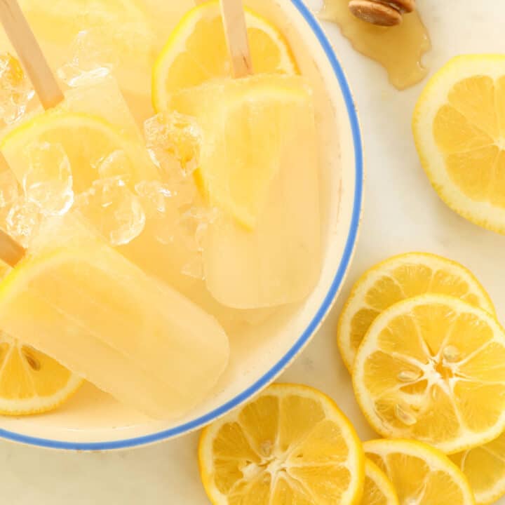 A white bowl filled with Lemon Ginger Popsicles.