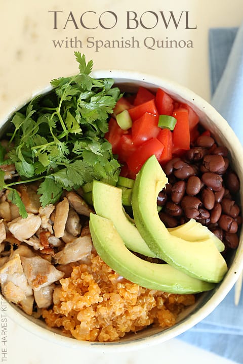 A white bowl with grilled chicken, Spanish quinoa, black beans, lettuce and avocado