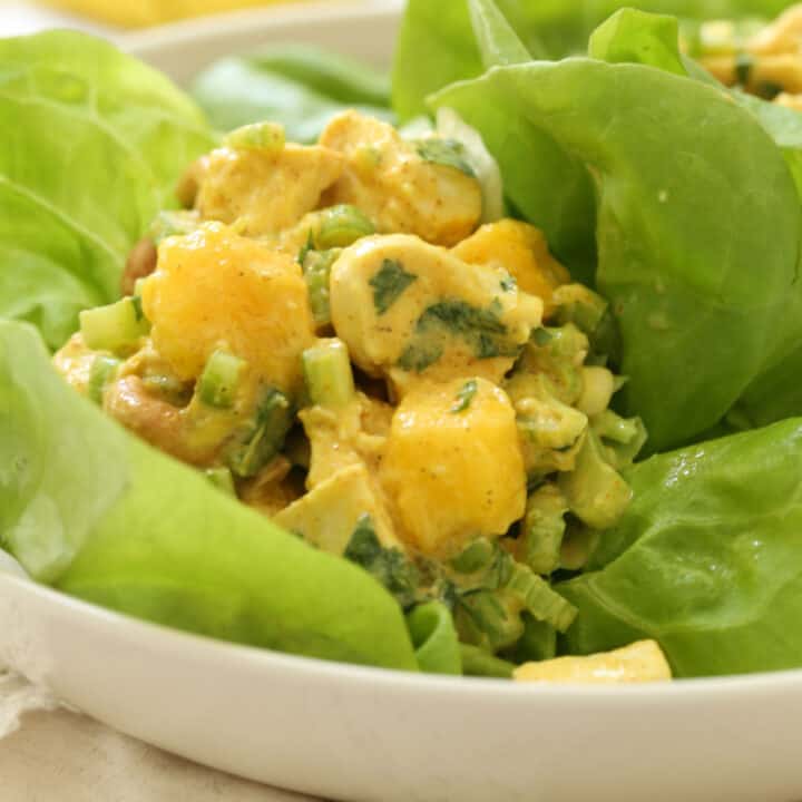 A white bowl filled with curried chicken salad with mango.