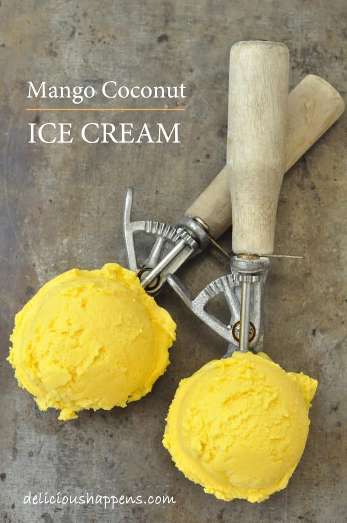 Two ice cream scoops with wooden handles have scoops of mango ice cream in them.
