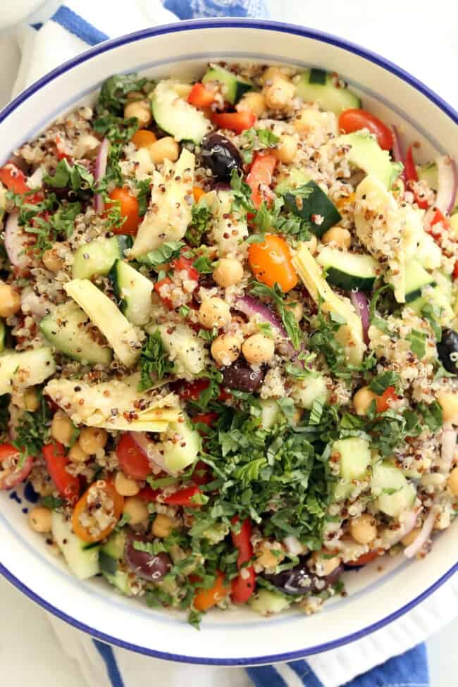 A large white bowl filled with Mediterranean quinoa salad.