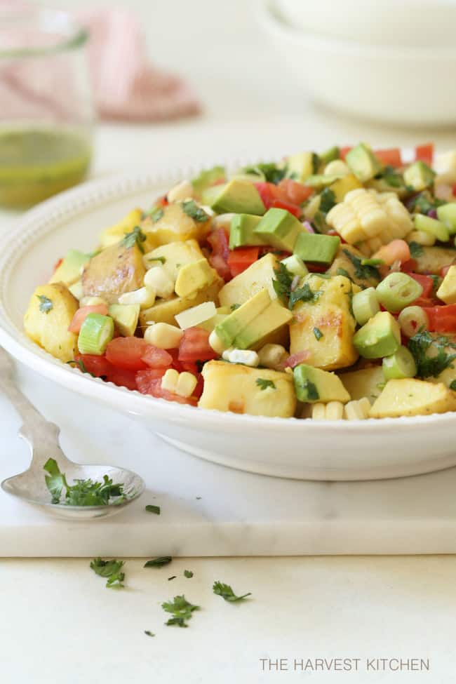 This Mexican Potato Salad is loaded with corn, tomatoes, avocado, green onion and cilantro all tossed in a cilantro lime vinaigrette