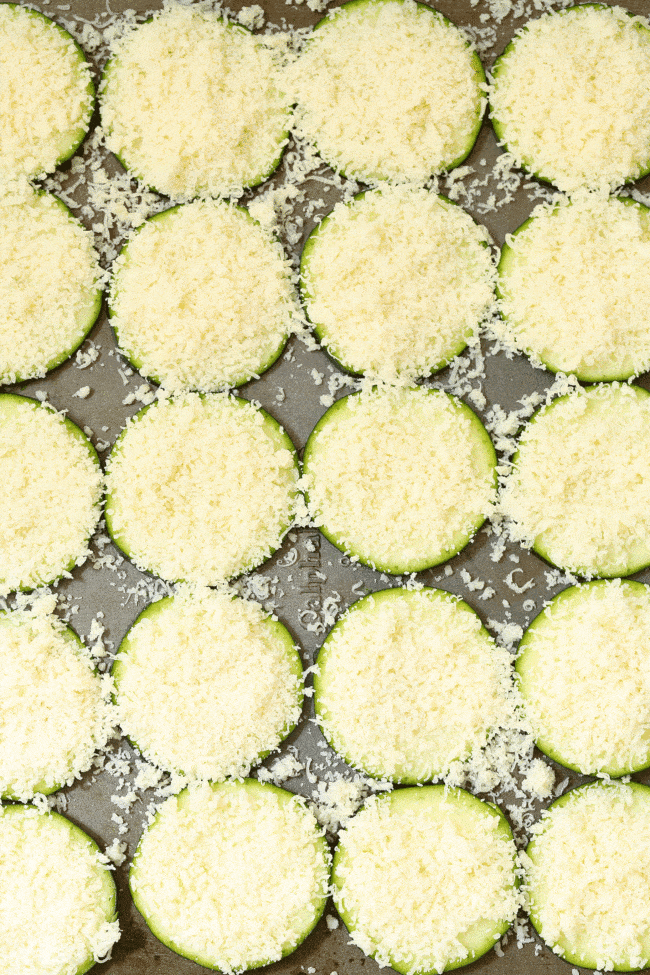 Sliced vegetables on a cookie sheet sprinkled with Parmesan cheese.