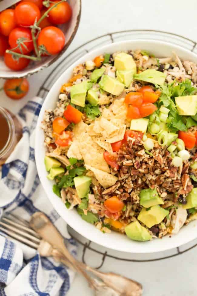 A white bowl filled with chopped vegetables and rotisserie chicken.