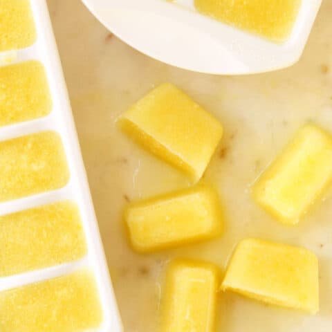 White ice cube trays filled with lemon ice cubes.