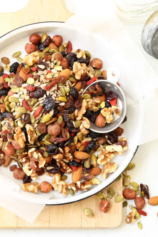 A round white enamelware pie tin filled with trail mix.