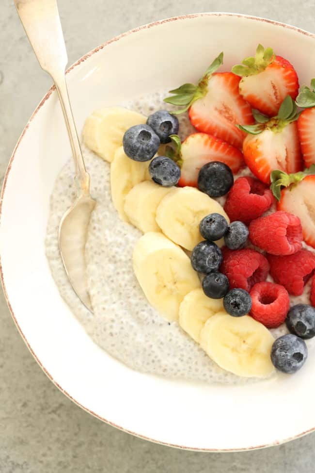 A white bowl filled with vanilla chia seed pudding and mixed fruit.