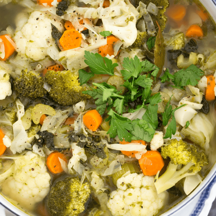 This Vegetable Soup is jam-packed with broccoli, cauliflower, cabbage, kale, carrots, celery, onion, garlic, parsley, basil and lemon