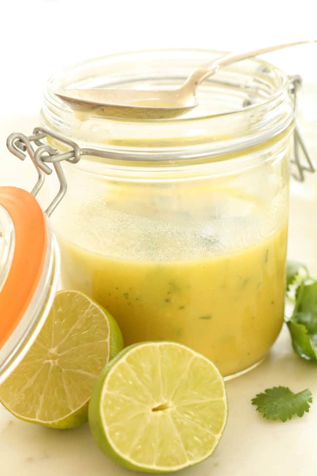 A clear glass mason jar filled with lime vinaigrette.