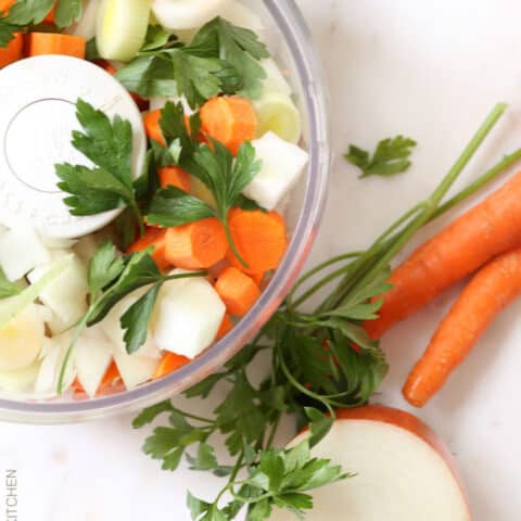 A food processor container filled with chopped vegetables.