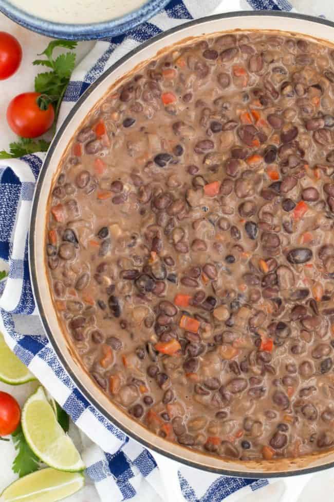 A large white pot filled with cooked legume stew.
