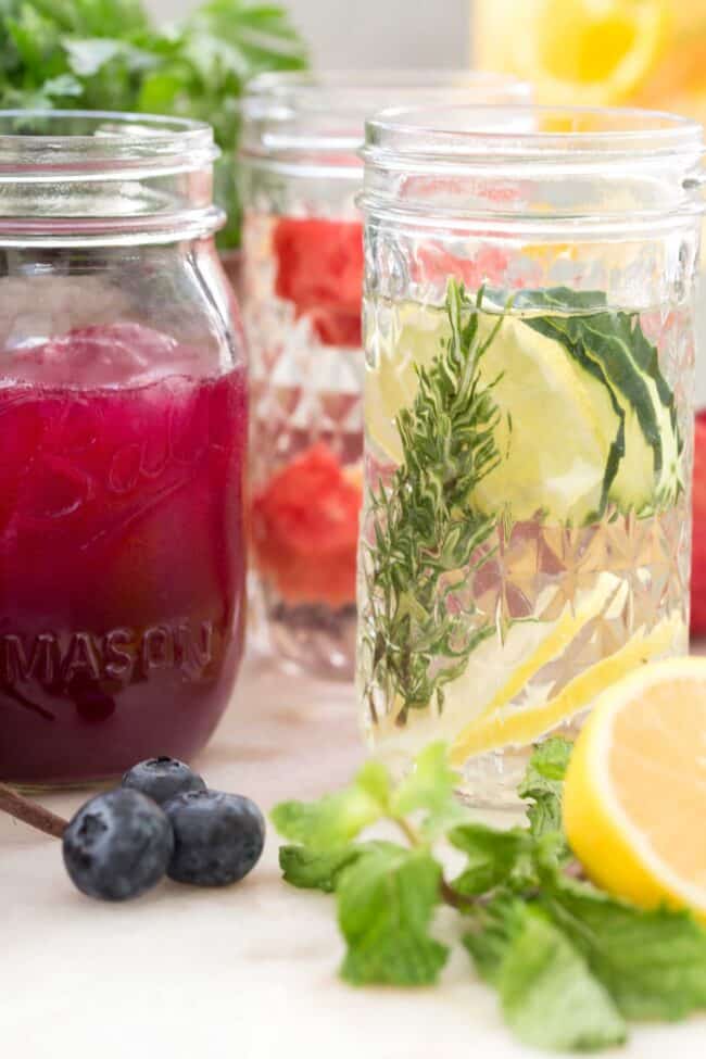 Two glasses filled with water and fruit.