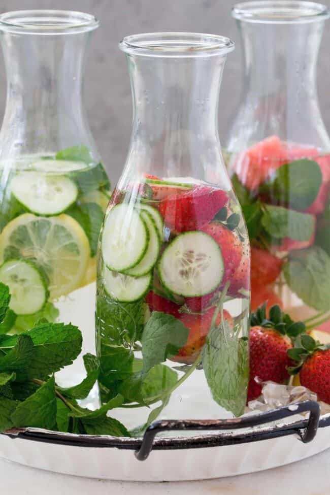 Three clear jars of fruit infused water.