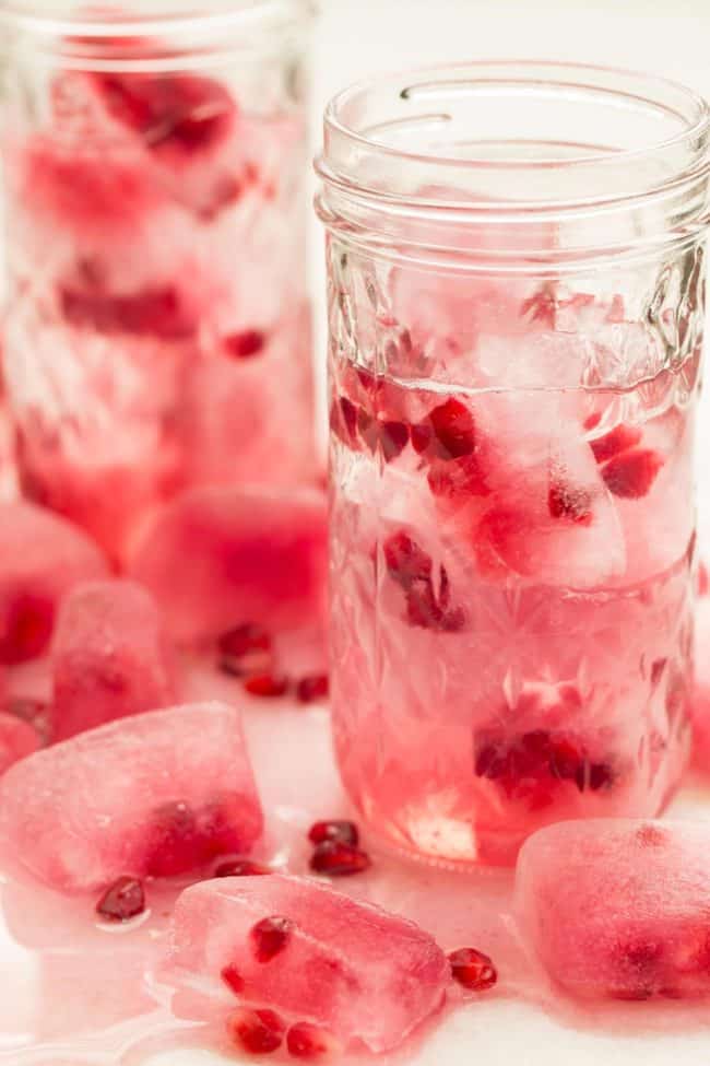 Two clear glasses filled with pomegranate water.