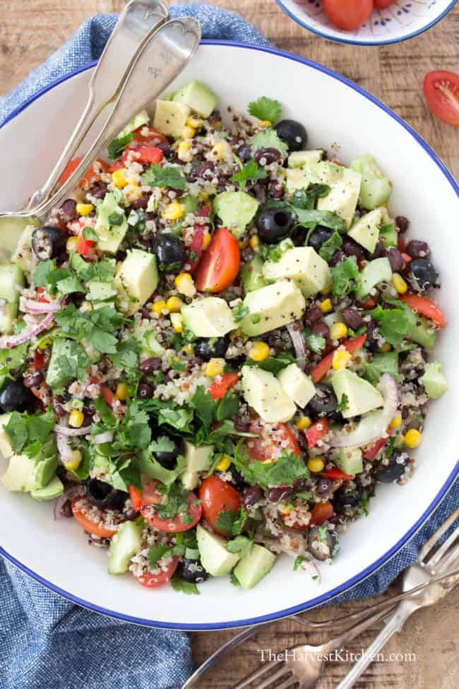 A white bowl of mixed greens and chopped vegetables.