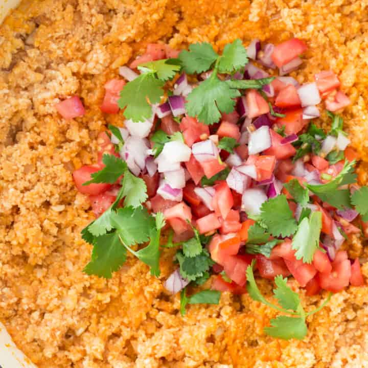 Mexican Cauliflower Rice (also called Spanish Cauliflower Rice) is made with cauliflower rice, onion, garlic, vegetable broth, tomato paste and seasoning