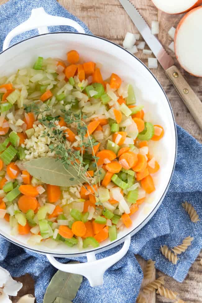 A white pot filled with chopped vegetables and fresh herbs.