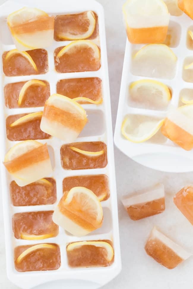 Two white ice cube trays filled with sweet tea ice cubes.