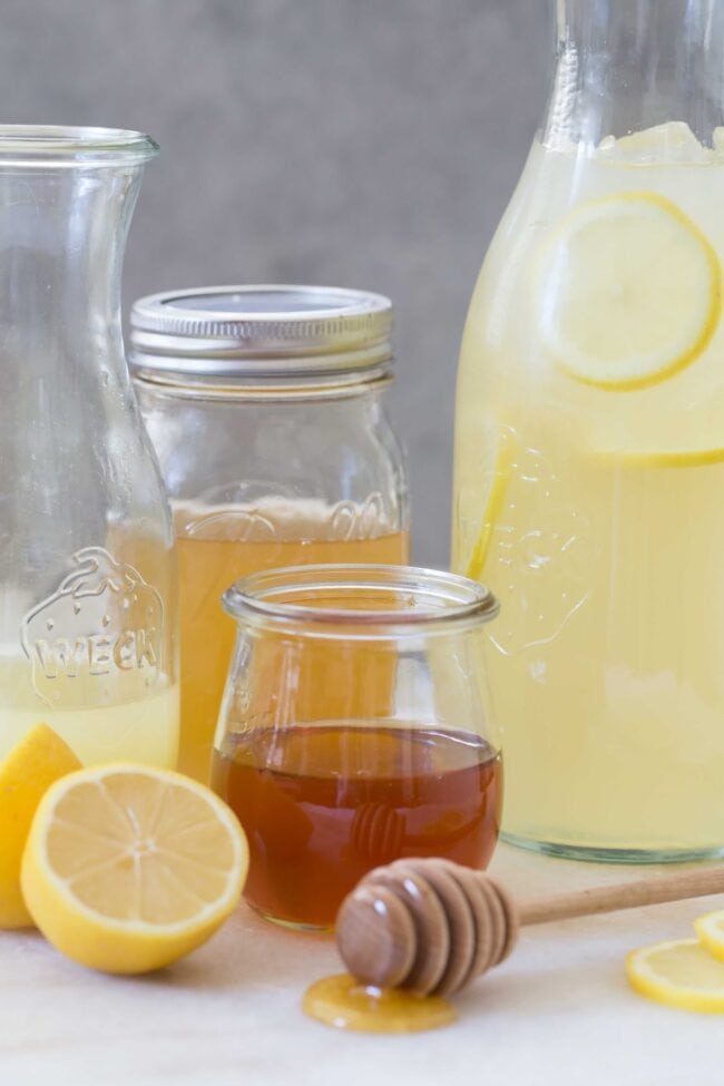 Glass Weck pitcher filled with honey lemonade and smaller Weck jar filled with honey and lemon juice.