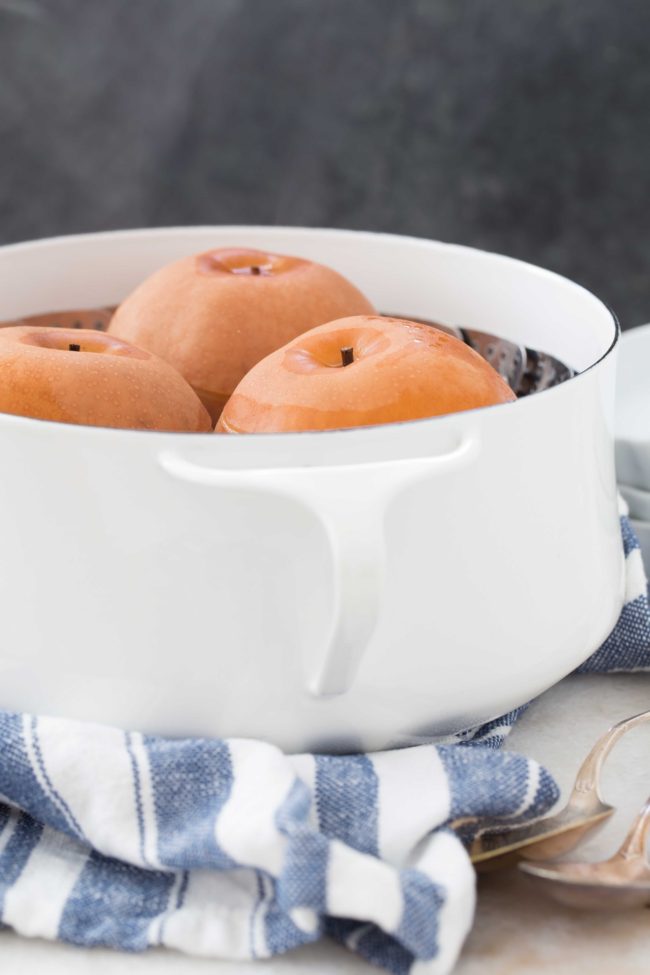 A white pot filled with water and fruit