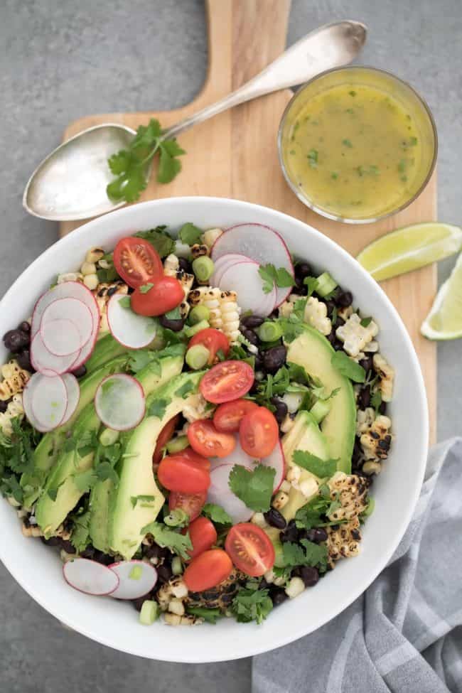 bowl of black beans and corn with tomatoes and avocado