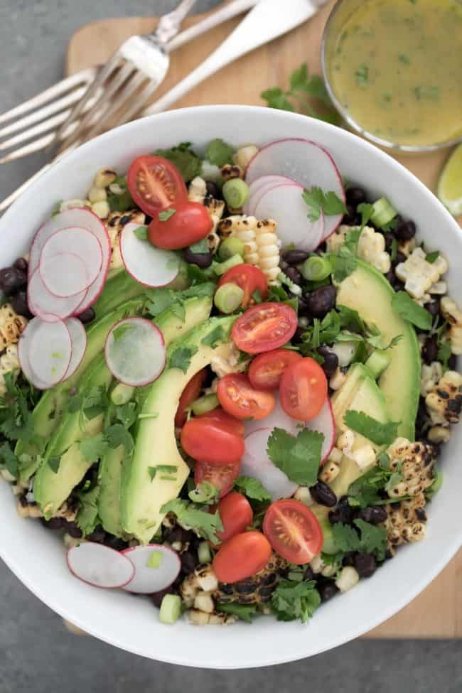 A white bowl of black bean and corn salad.