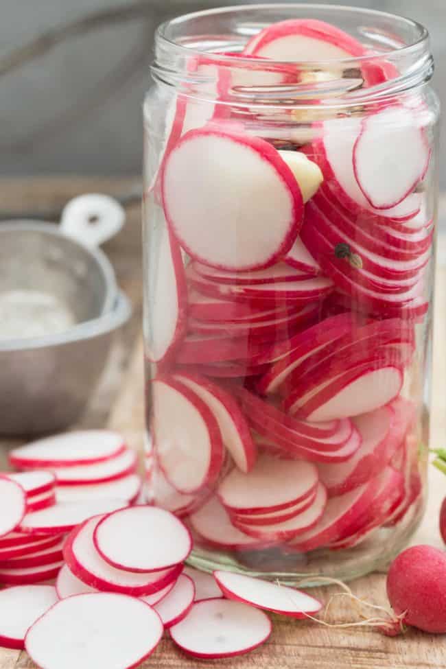 A clear mason jar filled with sliced vegetables.